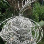 An Artful Gardener Garden Art Wire Figure Flute Player Hat and Feather detail